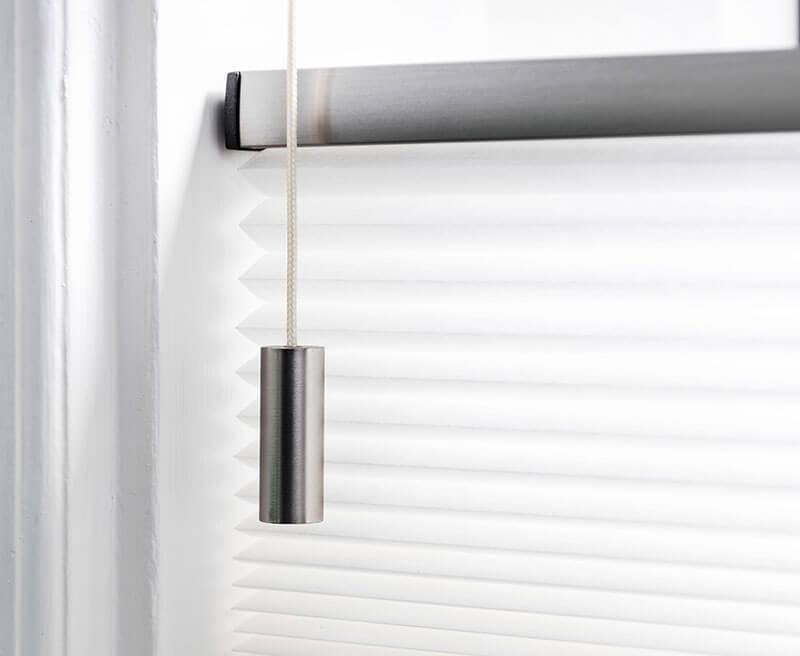 Hvidt duette-gardin med en SmartCord-betjeningssnor.