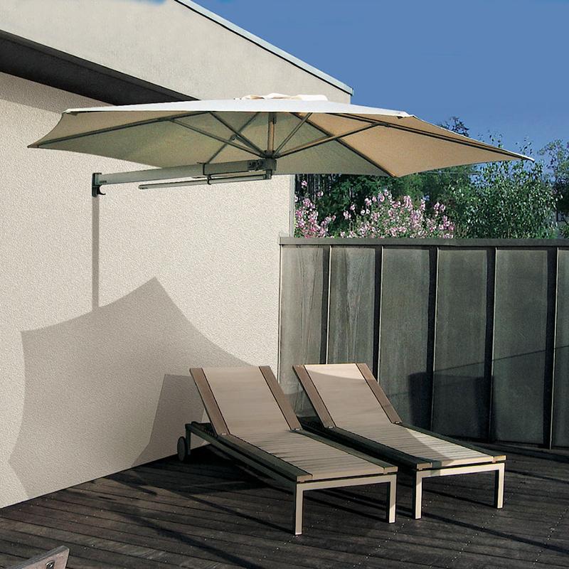 Hvid parasol der står ved to liggestole, som er placeret på terrasse.