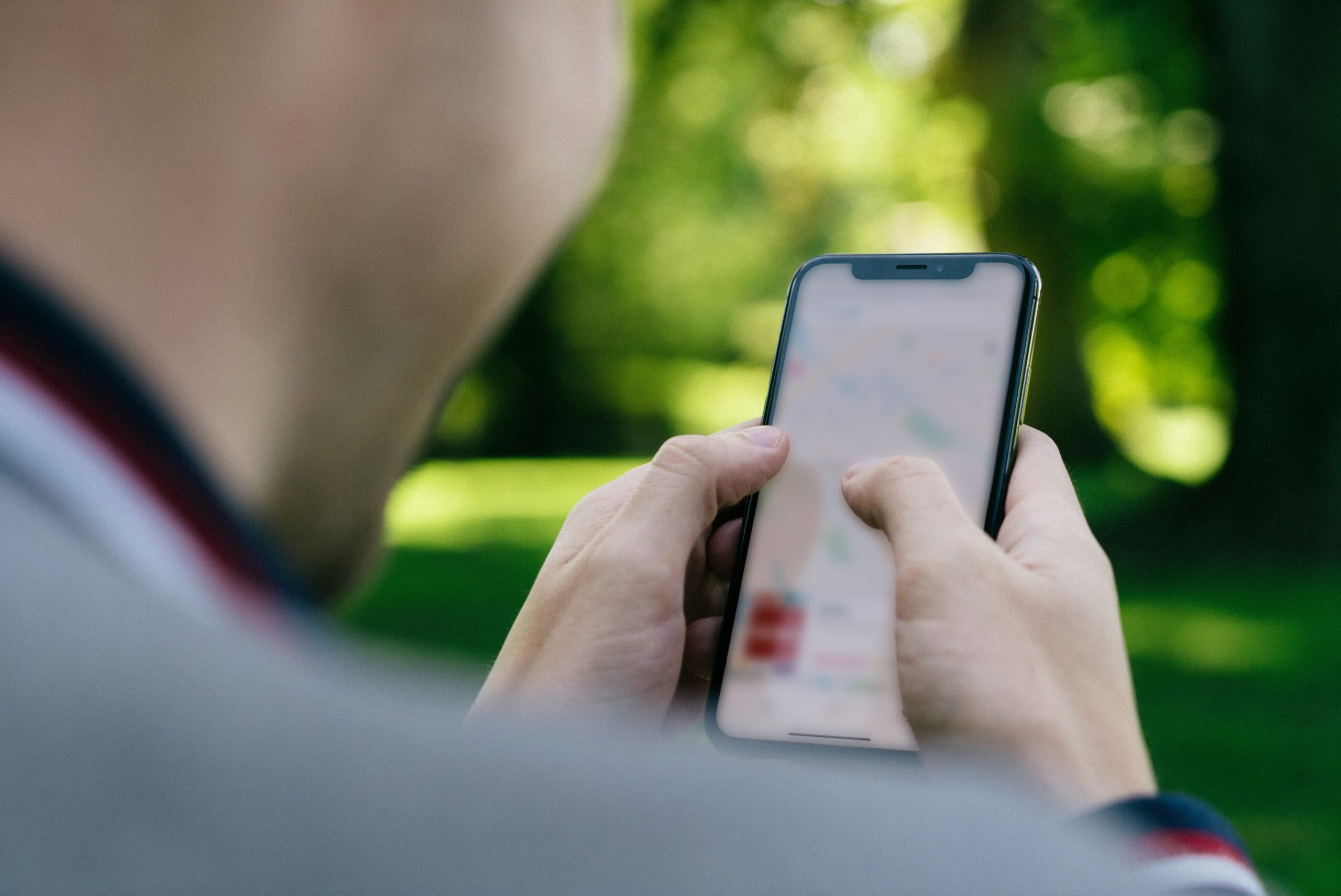 Person holder en smartphone i hånden og styrer sit gardin via den.