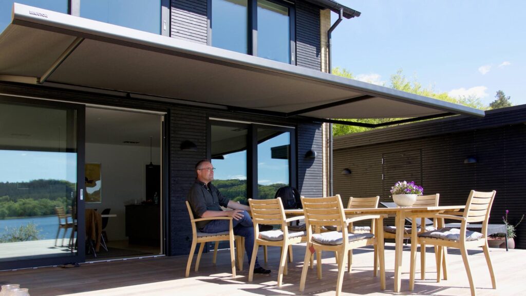Peter Ingemann der sidder på sin terrasse under sin markise.